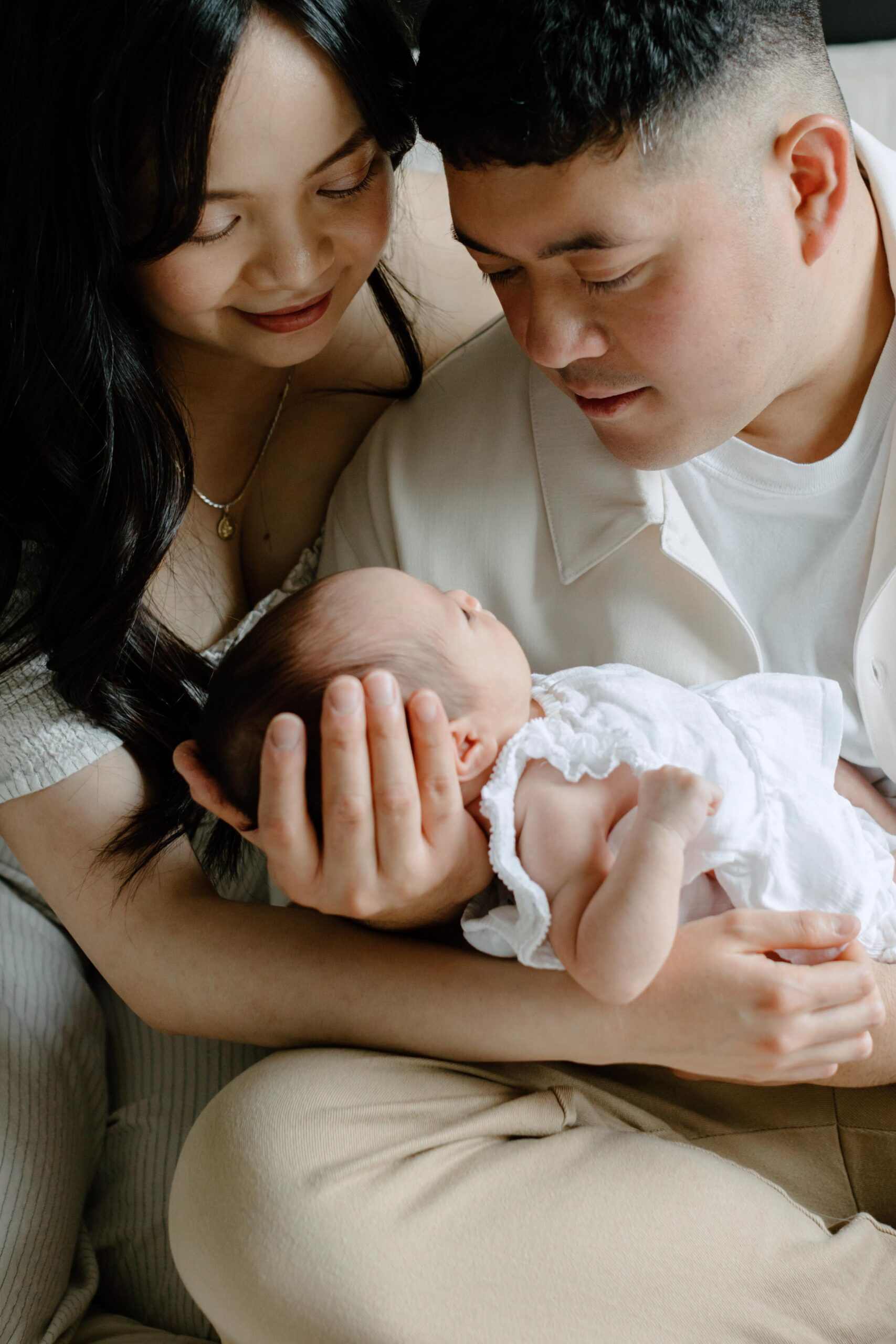 dad and mom hold their newborn daughter