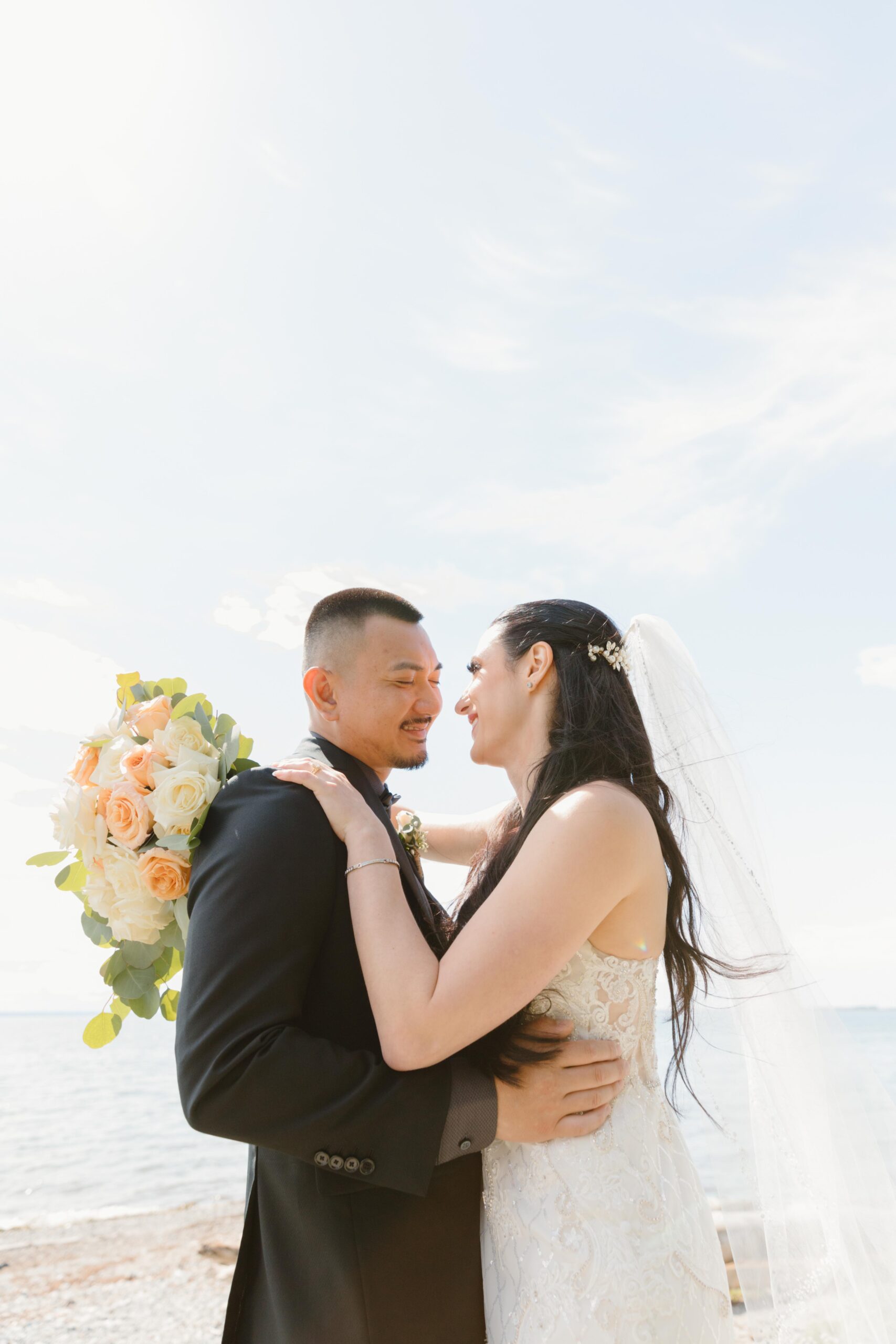 Married couple hugging under a blue sky