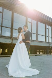 married man and woman hug outside with a sun flare