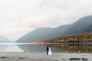 couple surrounded by water and the mountains at sunset