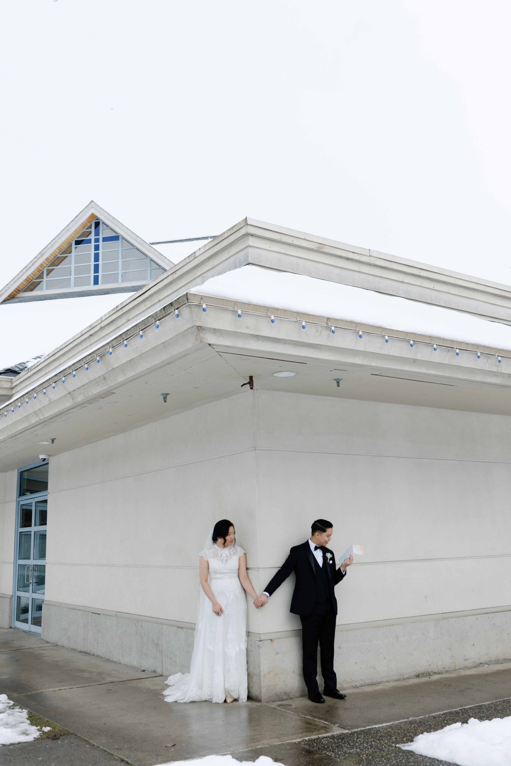 wedding groom and bride holding hands reading letters to each other